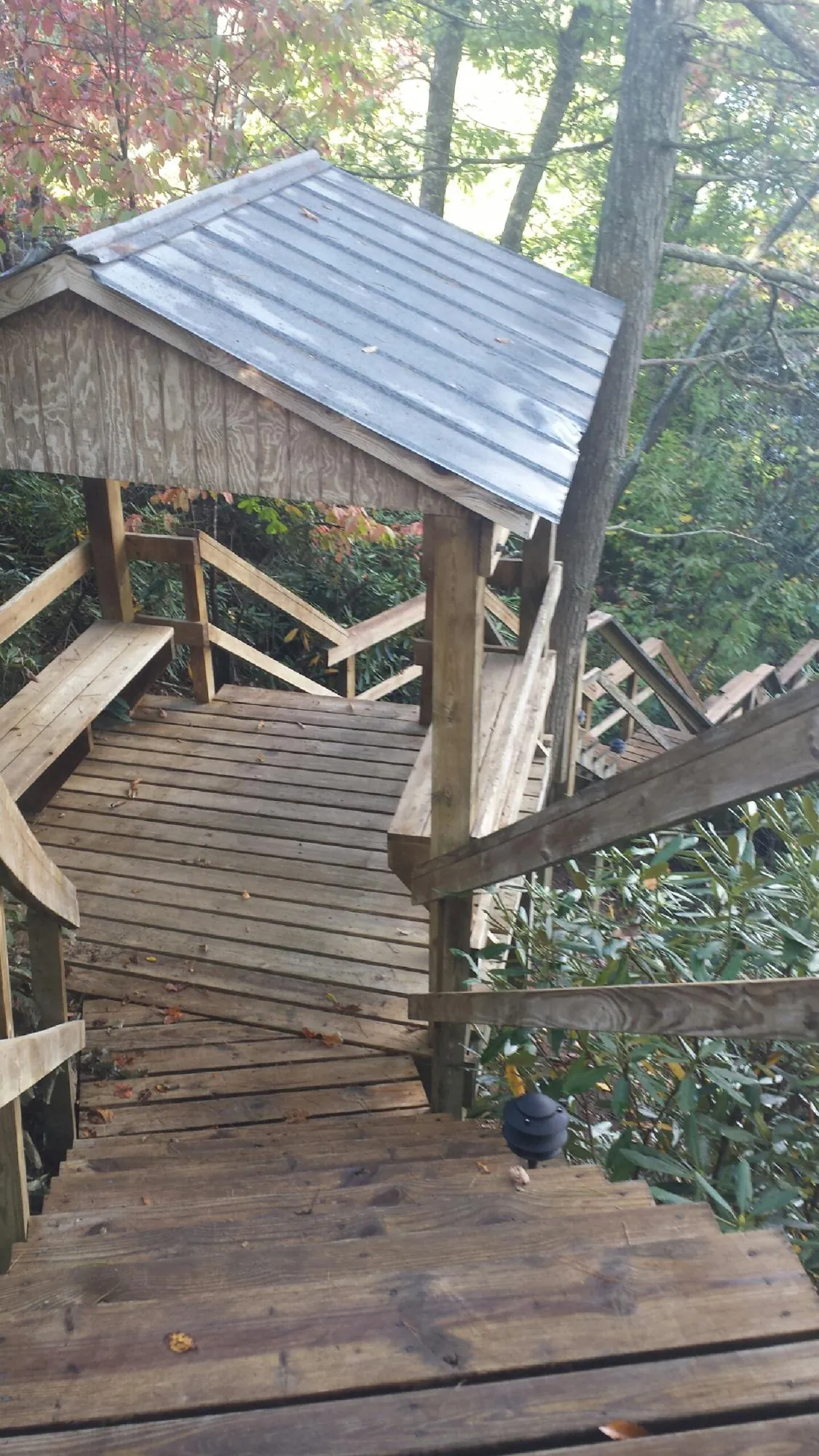 Metal roofed shelter over wooden steps on a wooded walkway — Skylight Repair & Installation work by our crew in Hinsdale